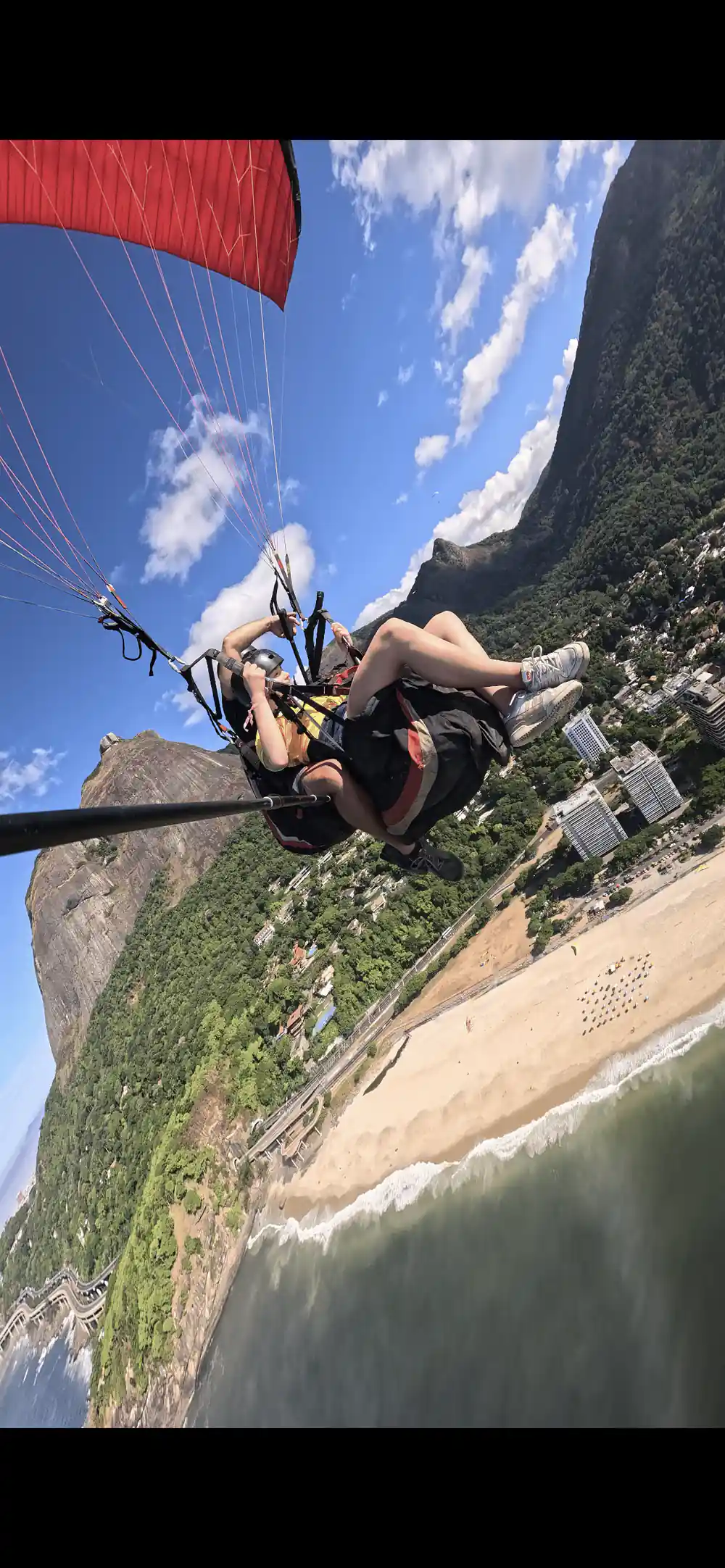 A tandem high over the beach with the mountain behind